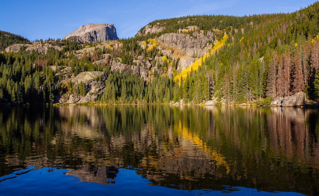 Hallette Peak and Fall-shrouded scenery reflected in the clear, cold water of Bear Lake at sunrise.