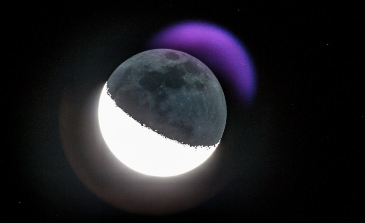 The moon, exposed to capture the dark part, resulting in a purplish crescent "moon flare" .